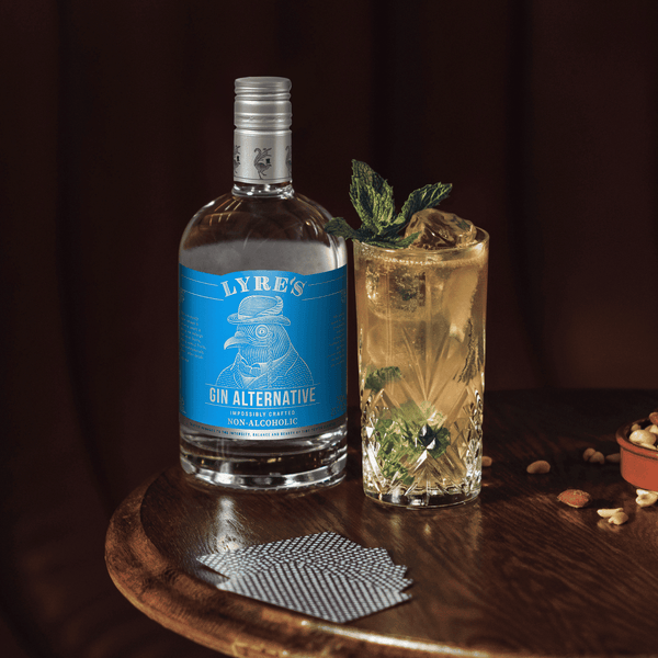 Lyre's Gin Alternative bottle next to a Gin Gin Mule mocktail